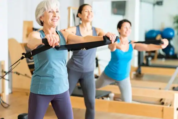 Toning Arms After 60: Empowering Womens Fitness Through Effective Weight Training 2 older woman doing weight training Earl Shilton and resistance in the gym to tone upper arms