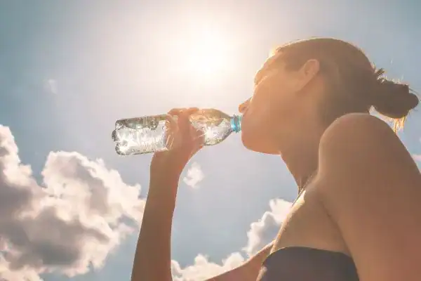 Hydration: The Secret Ingredient for a Toned Stomach and Enhanced Fitness 3 Image of woman drinking water to hydrate Earl Shilton after run.