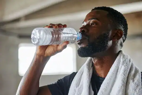 Image of man drinking water to improve hydration Earl Shilton after work out.